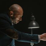 A detective presenting evidence during an intense interrogation scene.